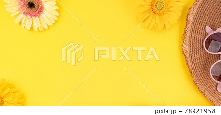 Yellow fashion holiday background with straw hat, sunglasses, gerbera daisy flowers on monochrome 78921958