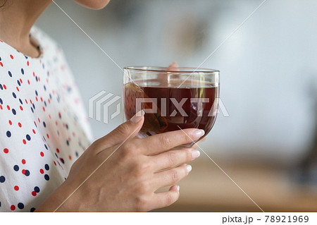 Close up cropped of woman holding cup of black tea Close up cropped of woman holding cup of black tea 78921969