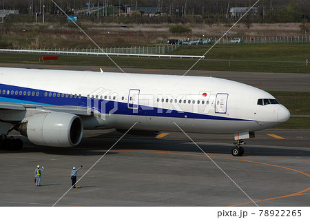 出発する飛行機に手を振る整備員の写真素材