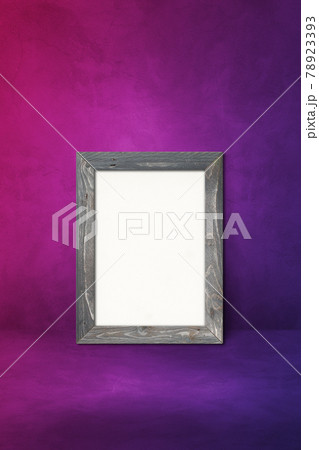 Wooden picture frame leaning on a purple wall 78923393
