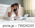 Asian woman lying down and smiling the bed and laptop 78926205