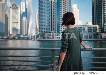 Happy young female traveler in the big city of Dubai, UAE Happy young female traveler in the big city of Dubai, UAE 78927605