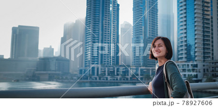 Happy young female traveler in the big city of Dubai, UAE Happy young female traveler in the big city of Dubai, UAE 78927606