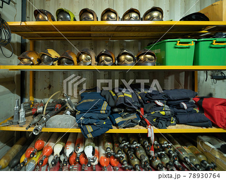Firefighter or fireman safety protection tools, extinguisher, uniform in a gear storage room, an emergency accident rescue safety and security equipment Firefighter or fireman safety protection tools, extinguisher, uniform in a gear storage room, an emergency accident rescue safety and security equipment 78930764