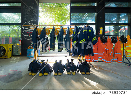 Firefighting or fireman clothes on rack at fire station storage, an emergency accident rescue safety and security equipment Firefighting or fireman clothes on rack at fire station storage, an emergency accident rescue safety and security equipment 78930784