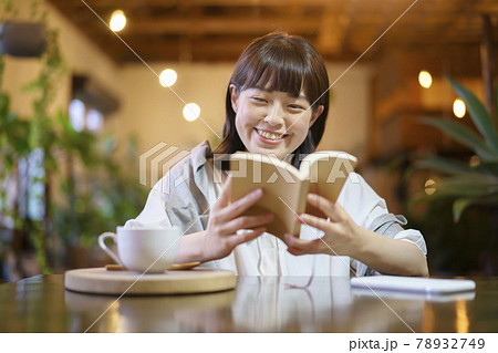 暖かい雰囲気の空間で、本を読む若い女性  78932749