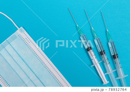 Syringe with Medical Mask on Blue Table - Flat Lay 78932764