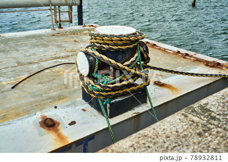 Side view of a cruciform bollard with mooring rope for securing a boat 78932811