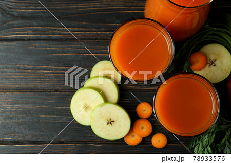 Glasses and pitcher with juice and ingredients on wooden background 78933576