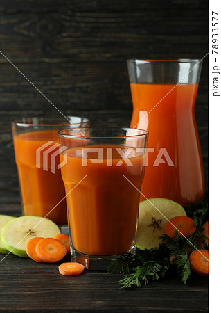 Glasses and pitcher with juice and ingredients on wooden background 78933577