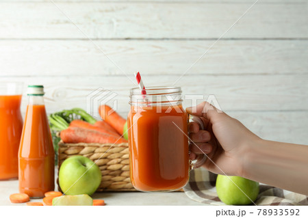Female hand hold jar with apple - carrot juice Female hand hold jar with apple - carrot juice 78933592