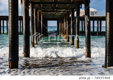 Turkey, Mediterranean Sea, on a pebble shore, waves break on the piles of a wooden pier Turkey, Mediterranean Sea, on a pebble shore, waves break on the piles of a wooden pier 78935468