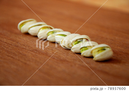 Salted pistachio nuts on wood texture background. Salted pistachio nuts on wood texture background. 78937600