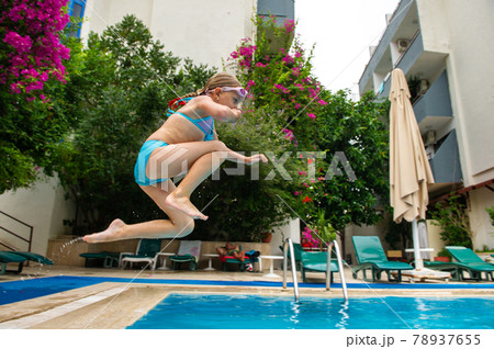 A girl in a blue swimsuit jumps into the pool. Marmaris, Turkey 78937655