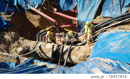 SELANGOR, MALAYSIA -NOVEMBER 03, 2016: Underground utilities trenches. Construction workers digging trenches to lay and install underground utility or services pipes at the construction site. SELANGOR, MALAYSIA -NOVEMBER 03, 2016: Underground utilities trenches. Construction workers digging trenches to lay and install underground utility or services pipes at the construction site. 78937859
