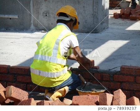 JASIN, MALAYSIA -SEPTEMBER 09, 2016: Brick walling joint and workmanship under construction at the construction site. Clay brick was attached together using cement mortar. JASIN, MALAYSIA -SEPTEMBER 09, 2016: Brick walling joint and workmanship under construction at the construction site. Clay brick was attached together using cement mortar. 78939237