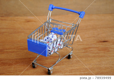 White dice in toy shopping trolley on wood texture background.  78939499
