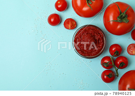 Bowl with tomato paste, tomatoes and salt on blue background Bowl with tomato paste, tomatoes and salt on blue background 78940125