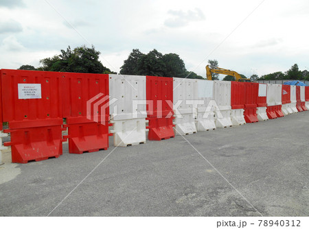 SELANGOR, MALAYSIA -DECEMBER 02, 2016: Plastic barrier or plastic barricade used as temporary boundary or road barrier to keep away public from construction working area. SELANGOR, MALAYSIA -DECEMBER 02, 2016: Plastic barrier or plastic barricade used as temporary boundary or road barrier to keep away public from construction working area. 78940312