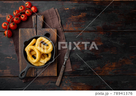 Rings of squid or onions in batter. Snack to beer. on cast iron frying pan skillet, on old dark wooden table background, top view flat lay, with copy space for text Rings of squid or onions in batter. Snack to beer. on cast iron frying pan skillet, on old dark wooden table background, top view flat lay, with copy space for text 78941376