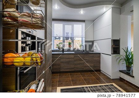 Modern luxury large brown kitchen with dining table and vertical drawer pulled out 78941577