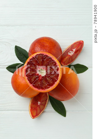 Red oranges and leaves on white wooden table 78941900