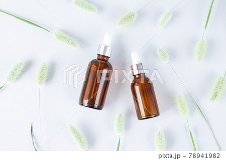 Glass brown dropper bottles mockup and flowers flat lay set of luxury organic cosmetic products top view Glass brown dropper bottles mockup and flowers flat lay set of luxury organic cosmetic products top view 78941982
