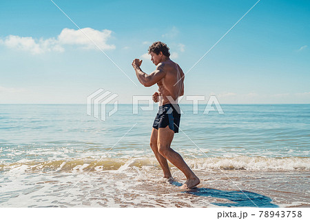 A muay thai or kickboxer training with shadow boxing outdoor at seashore 78943758