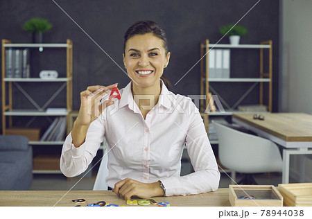 Webcam portrait of happy teacher teaching letters to primary students in online class Webcam portrait of happy teacher teaching letters to primary students in online class 78944038