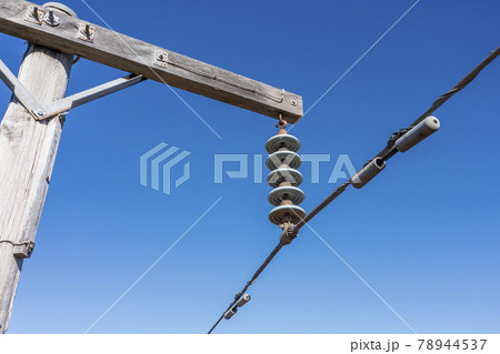 Drone aerial photograph of a wooden telephone pole and wires in a forest 78944537