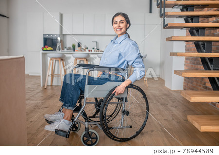 Positive handicapped young woman at home and looking happy Positive handicapped young woman at home and looking happy 78944589