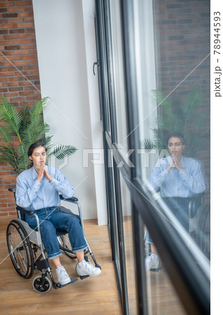 Young dark-haired handicapped woman looking thoughtful Young dark-haired handicapped woman looking thoughtful 78944593