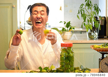 ウメシュと梅の実を持ち笑顔のシニア男性 78946840