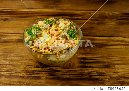 Tasty salad with chicken breast, roasted mushrooms, carrots, grated cheese, eggs and mayonnaise on wooden table 78953095