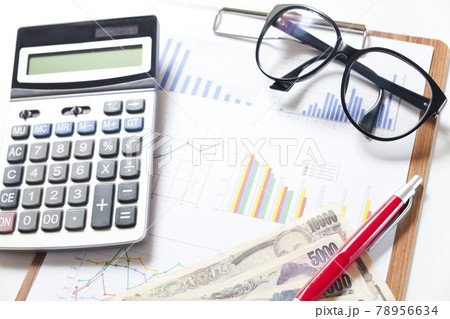 Financial accounting stock market graphs and charts analysis with pen and calculator on table. Financial accounting stock market graphs and charts analysis with pen and calculator on table. 78956634