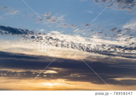 Beautiful blue sky at sunset with golden fluffy clouds.  78958347