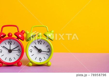 green and red vintage alarm clock on yellow color background. green and red vintage alarm clock on yellow color background. 78958796