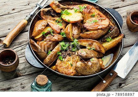 Chicken baked with potatoes in a iron cast pan Chicken baked with potatoes in a iron cast pan 78958897