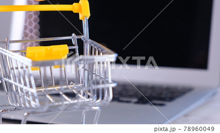 shopping basket next to a laptop on background. Copy space. Online shopping concept. shopping basket next to a laptop on background. Copy space. Online shopping concept. 78960049