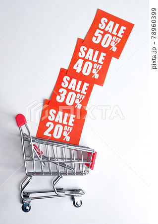 A Trolley with red labels in the form of discounts on a white background. The concept of stock sales. Vertically. 78960399
