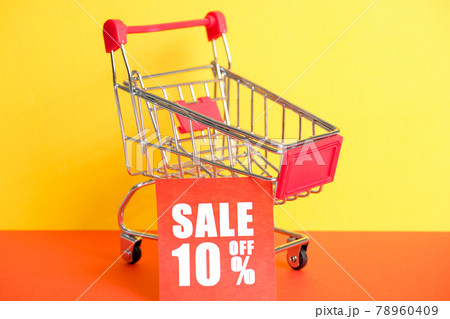 Trolley on a red-yellow background with the announcement of a 10% discount. The concept of sales. Close up. 78960409