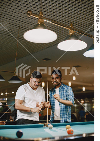 Men playing billiards in a club 78960528