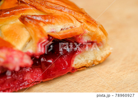 Cake from dough with cherry filling on a wooden board. Close up. Cake from dough with cherry filling on a wooden board. Close up. 78960927