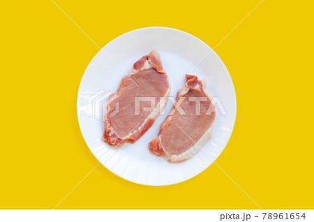 Fresh pork in white plate on yellow background. Fresh pork in white plate on yellow background. 78961654