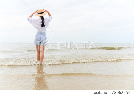 Outdoor summer portrait of young asian woman in straw hat looking to the sea at tropical beach, enjoy freedom time, fresh air and leisure travel vacation. Outdoor summer portrait of young asian woman in straw hat looking to the sea at tropical beach, enjoy freedom time, fresh air and leisure travel vacation. 78962256
