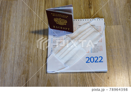Medical mask and calendar 2022. Sanitary mask and passport on the table. Russian passport and calendar. 78964398