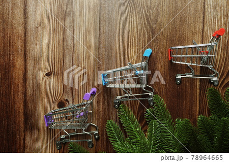 Mini Shopping Trolley  with fir tree branches border frame on wooden background 78964665