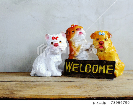 ceramic dog with welcome sign on wooden background ceramic dog with welcome sign on wooden background 78964796