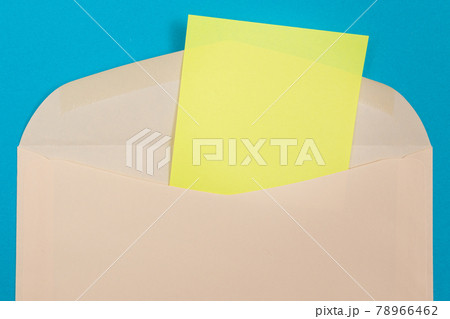 Beige Envelope with Blank Yellow Sheet of Paper Inside 78966462
