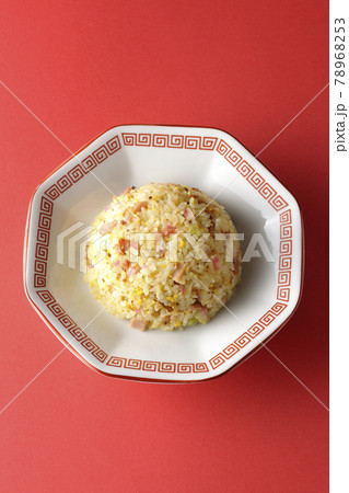 鳴門巻きやチャーシューなど色々な具材が入った単品五目チャーハンを赤色の背景で俯瞰撮影 78968253
